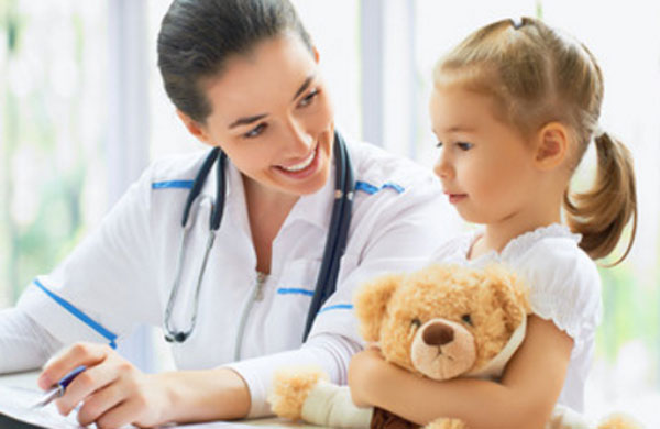 Девочка с плюшевым медведем в руках разговаривает с доктором