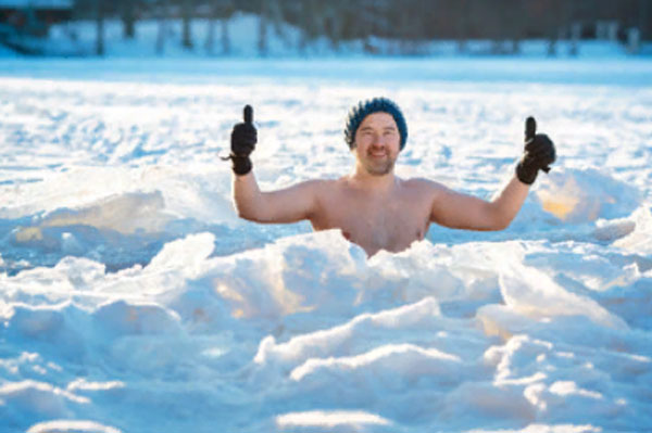 Мужчина в проруби. На нем надета шапка и перчатки