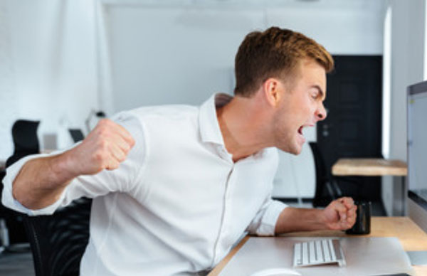 Мужчина в ярости. хочет разбить кулаком монитор