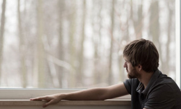 Мужчина сидит у окна