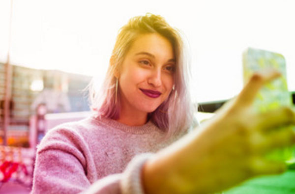 Девушка делает селфи посреди улицы