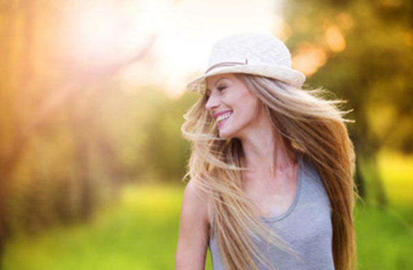 Счастливая девушка в шляпке прогуливается по улице