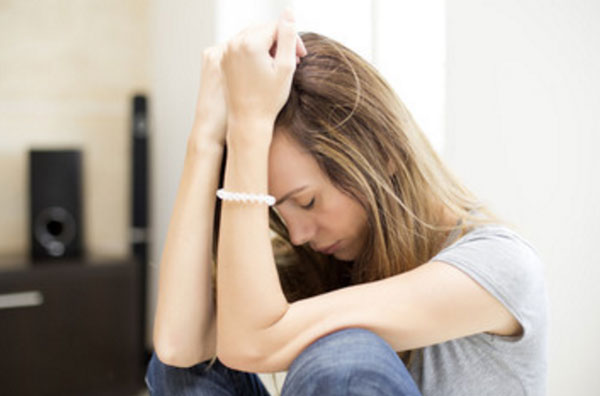 Огорченная девушка сидит на полу