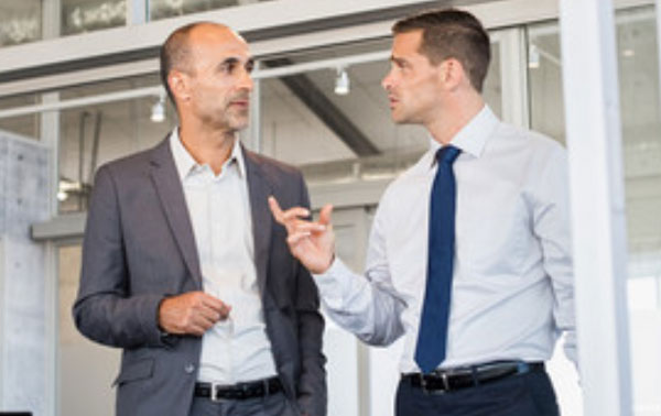 Два мужчины общаются. Один жестикулирует рукой