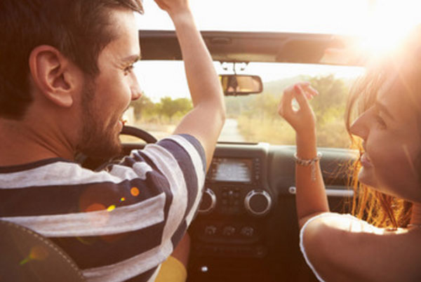 Парень с девушкой едут в машине. Вид с заднего сидения