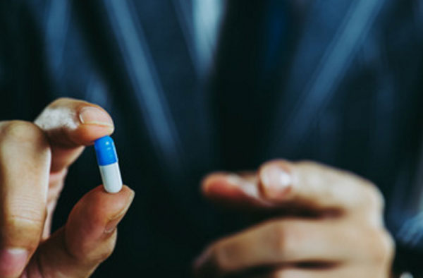 Мужчина в руке держит капсулу