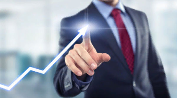 Мужчина в костюме указывает пальцем на стрелку,возрастающую вверх