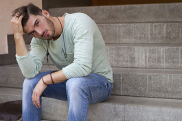 Парень сидит на ступеньках