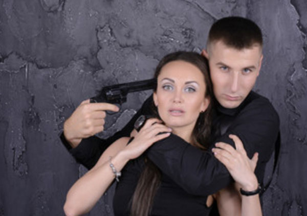 Мужчина схватил женщину, угрожает ей оружеем