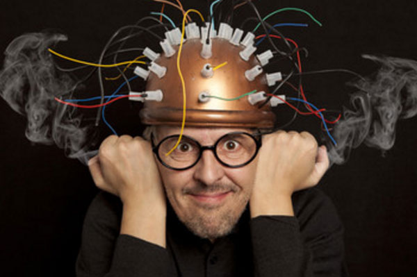 Мужчина со шлемом на голове, из которого торчат провода и из ушей идет дым