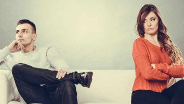 Муж с женой поссорились. Сидят на разных краях дивана. Жена смотрит на супруга