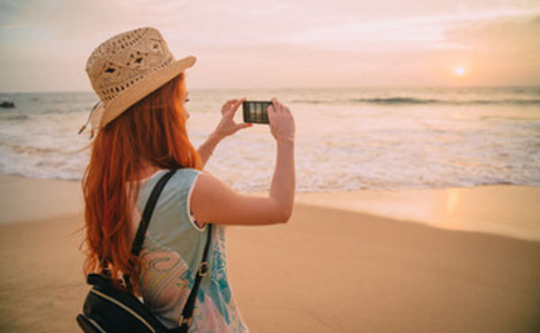 Девушка на отдыхе, фотографирует море