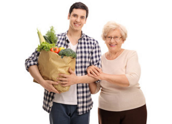 Парень несет покупки бабушки