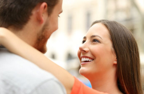 Девушка обнимает парня. смотрит влюбленно ему в глаза