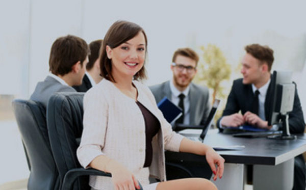 Харизматичная женщина сидит за столом с мужчинами