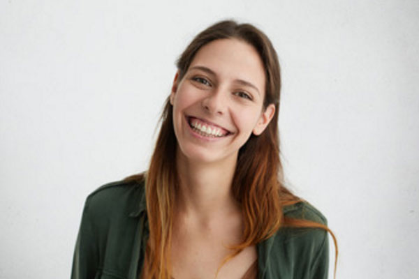 Женщина в зеленой кофте улыбается