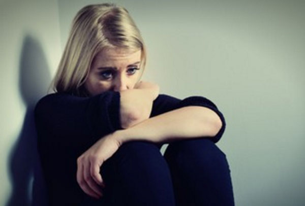 Грустная женщина сидит в углу