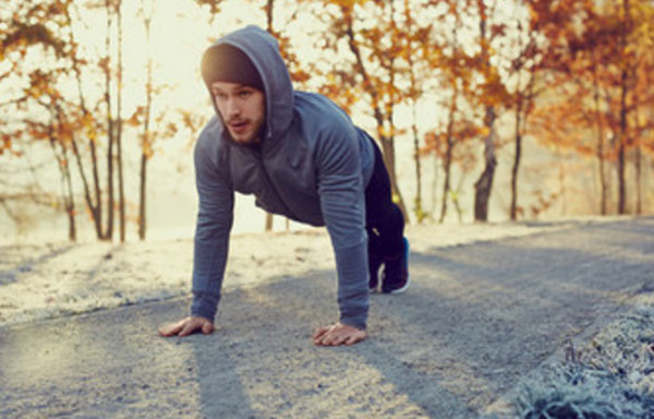 Мужчина держит планку на улице в холодное время года