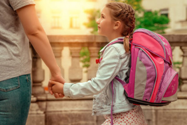 Девочка с рюкзаком на спине смотрит на маму заплаканными глазами