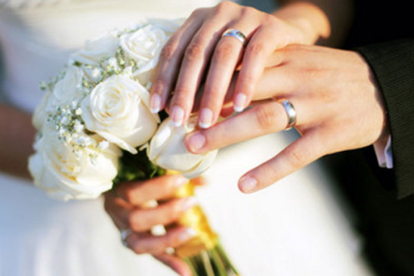 Свадебный букет и руки с обручальными кольцами