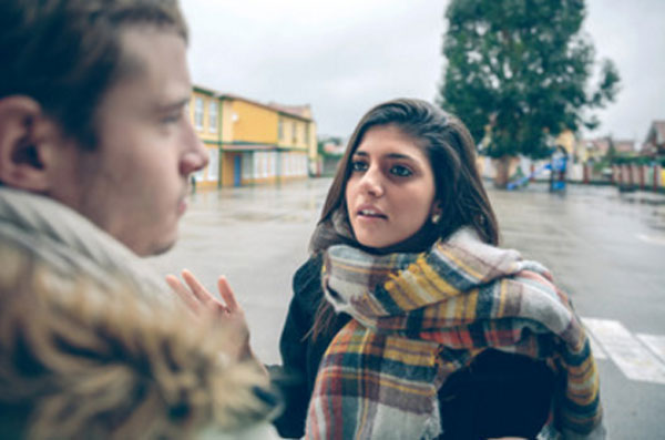 Девушка высказывает своему парню претензии, стоя на улице