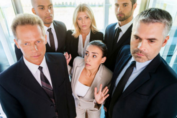 Женщина стоит в окружении людей. Ей страшно