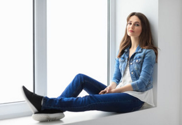 Девушка сидит на подоконнике