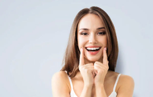 Девушка пальцами касается краев своей улыбки