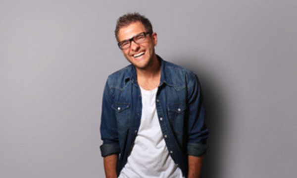 Мужчина в очках смеется