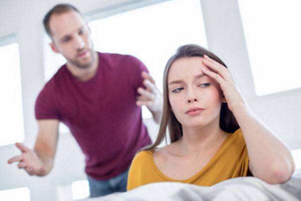 Женщина обижена. На заднем плане мужчина пытается ей что-то объяснить