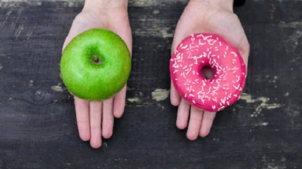 Две ладони. На одной лежит яблоко, на другой - пончик