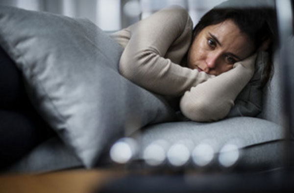 Женщина лежит в постели. У нее депрессия