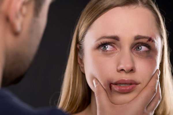 Избитая девушка. Мужчина держит ее за лицо