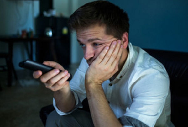 Грустный мужчина сидит с пультом в руках