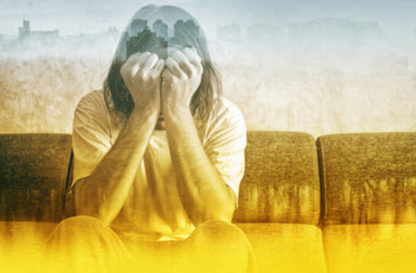 Силуэт человека, который сидит прикрывая лицо руками