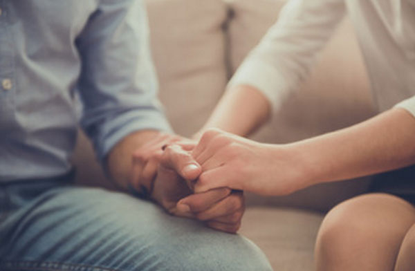 Женщина держит мужчину за руку