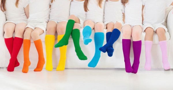 Девочки сидят на диване в носках, у каждой свой цвет