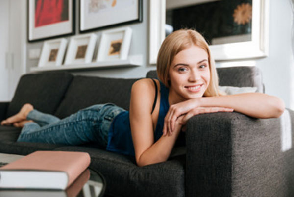 Улыбающаяся девушка лежит на диване