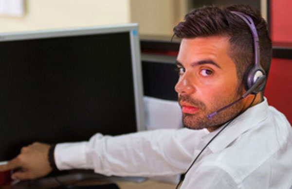 Мужчина с гарнитурой на голове собирается включить компьютер