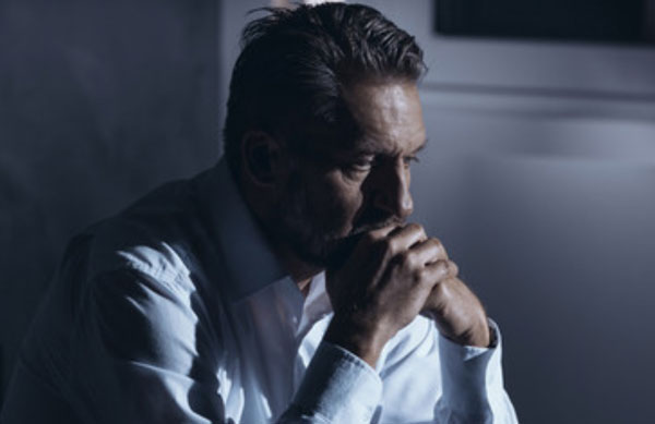 Расстроенный мужчина сидит в задумчивости