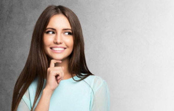 Девушка с улыбкой на лице о чем-то задумалась