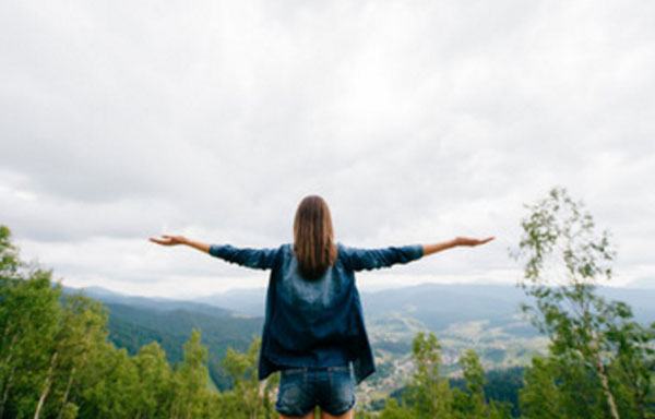 Девушка на природе. Стоит с распростертыми руками