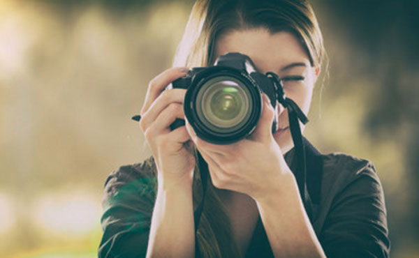 Девушка с фотоаппаратом делает снимок