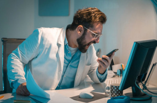 Мужчина кричит на мобильный телефон