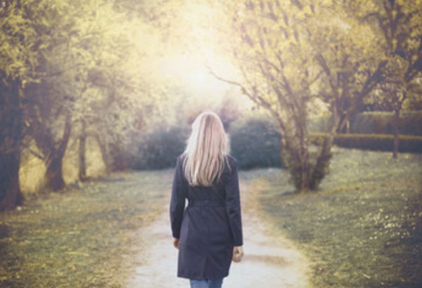 Женщина идет по тропинке. Гуляет по парку