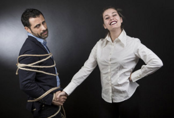 Женщина стоит рядом со связанным мужчиной