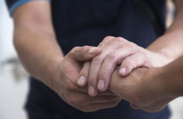 Мужчина держит другого человека за руку