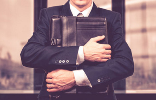 Мужчина прижимает к себе портфель