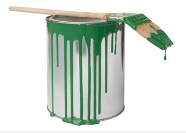 Банка с зеленой краской, на которой лежит кисточка испачканная в зеленой краске