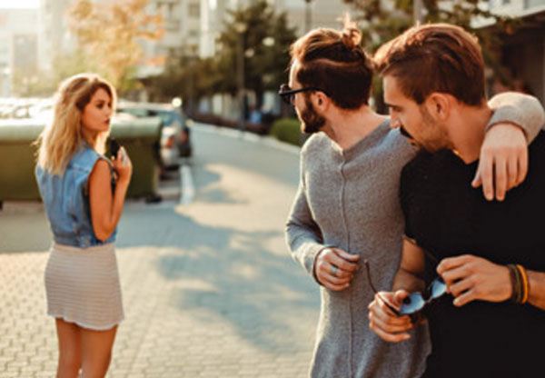 Два мужчины смотрят вслед уходящей женщине